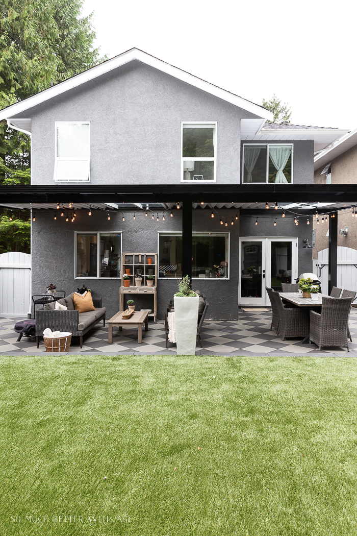 Black aluminum awning with artificial turf in backyard.