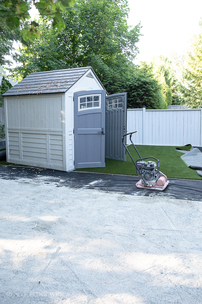 Shed sitting on artificial turf while it's getting installed.