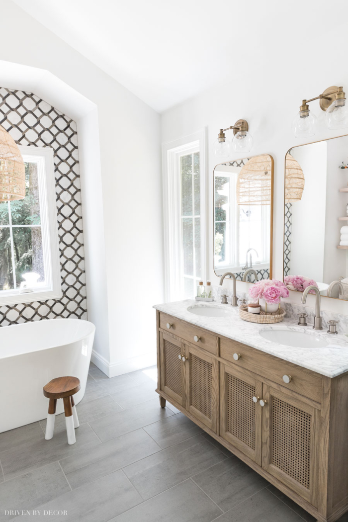 Driven By Decor renovated bathroom with white walls and wooden and marble vanity. 