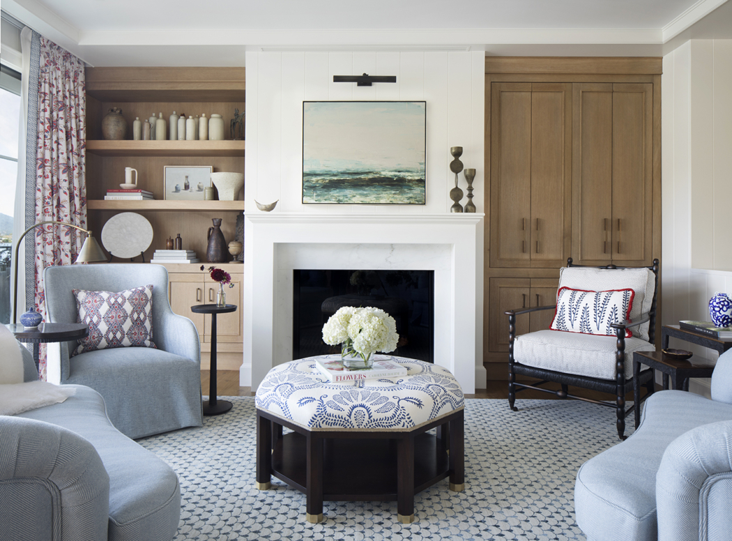 Living room by Julie Rootes with wooden built-in cabinets and four upholstered chairs and ottoman. 