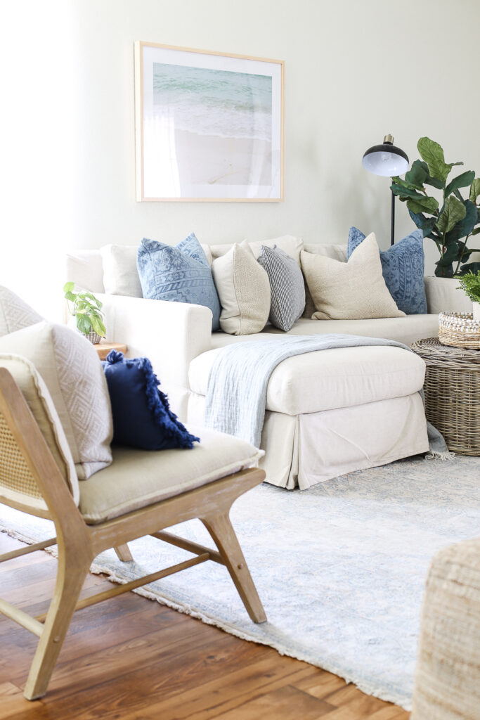 Making Home Base living room with slipcovered white sectional and blue cushions. 