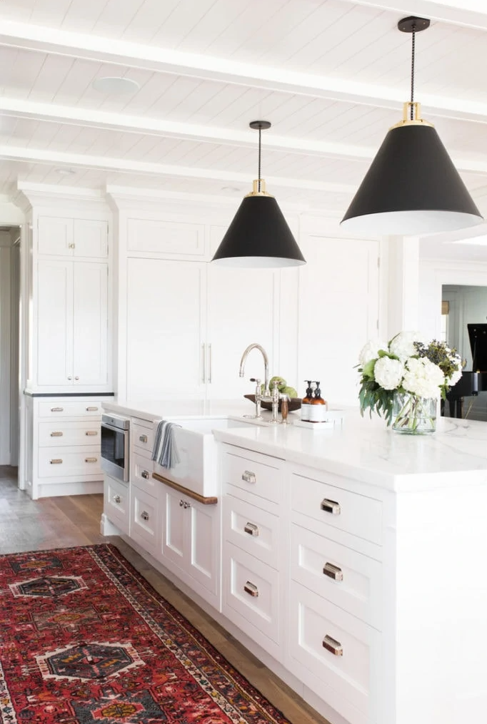 Kitchen by Studio McGee with red vintage runner and black pendant lights over the island. 