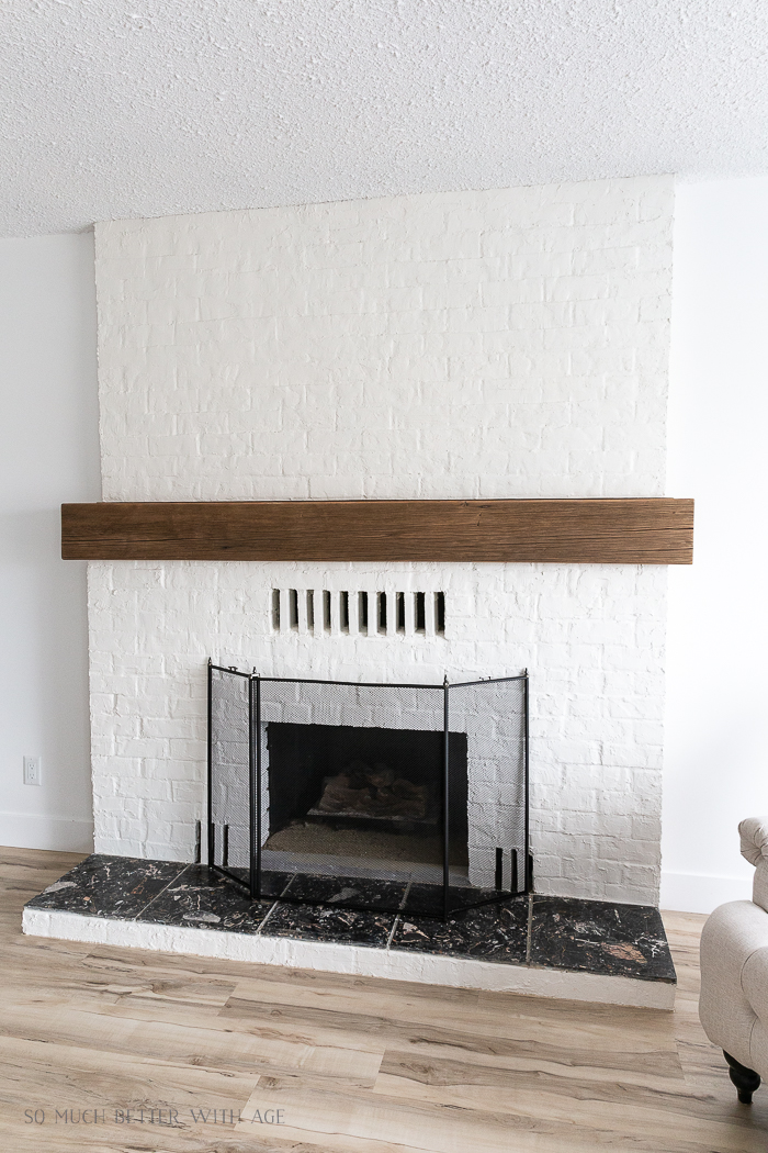 Plastered brick fireplace with wood mnatel. 