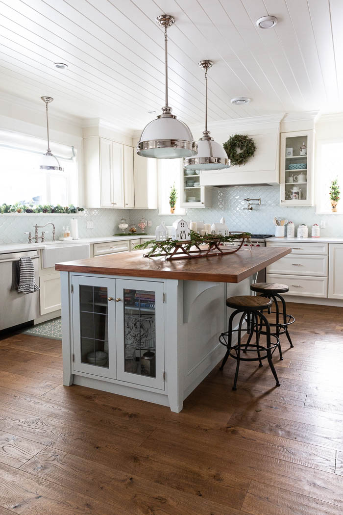 Big farmhouse kitchen with shiplap ceiling and large wooden island. 
