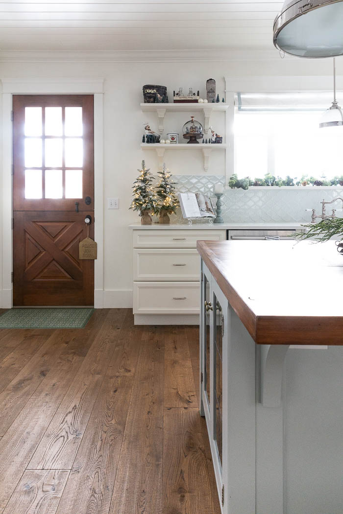 Large farmhouse kitchen decorated for Christmas with wooden dutch door. 