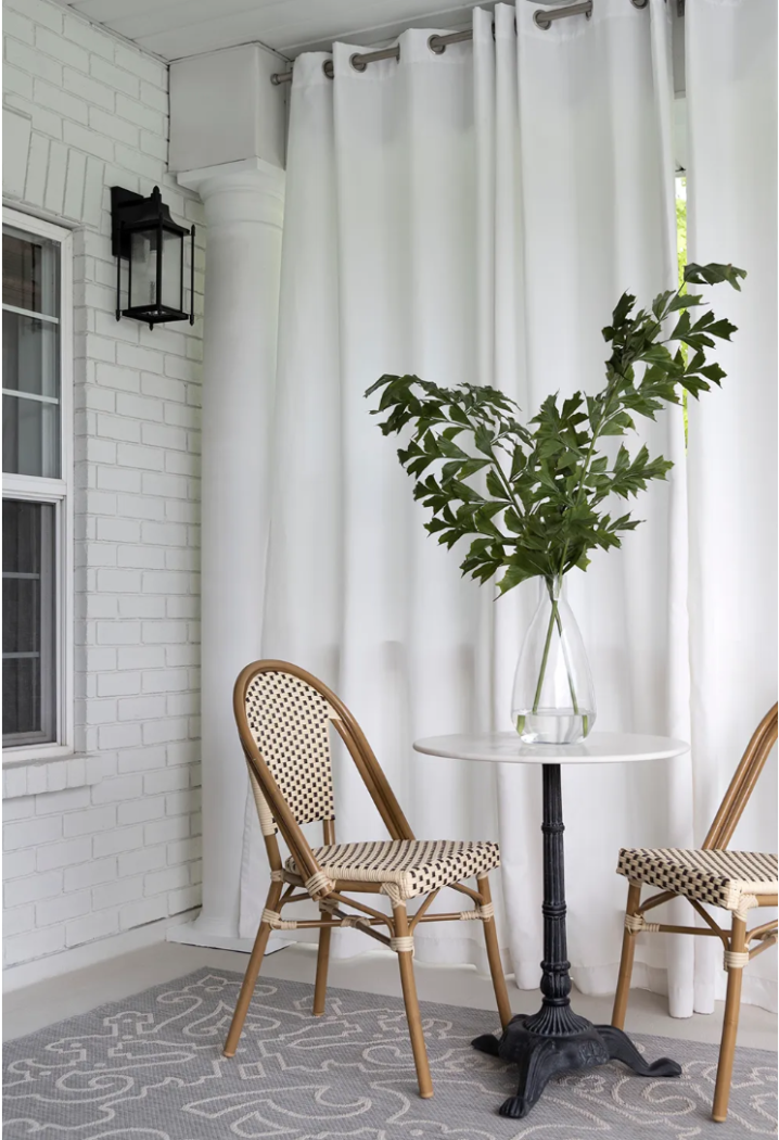 French bistro chairs with marble round table on outdoor patio. 