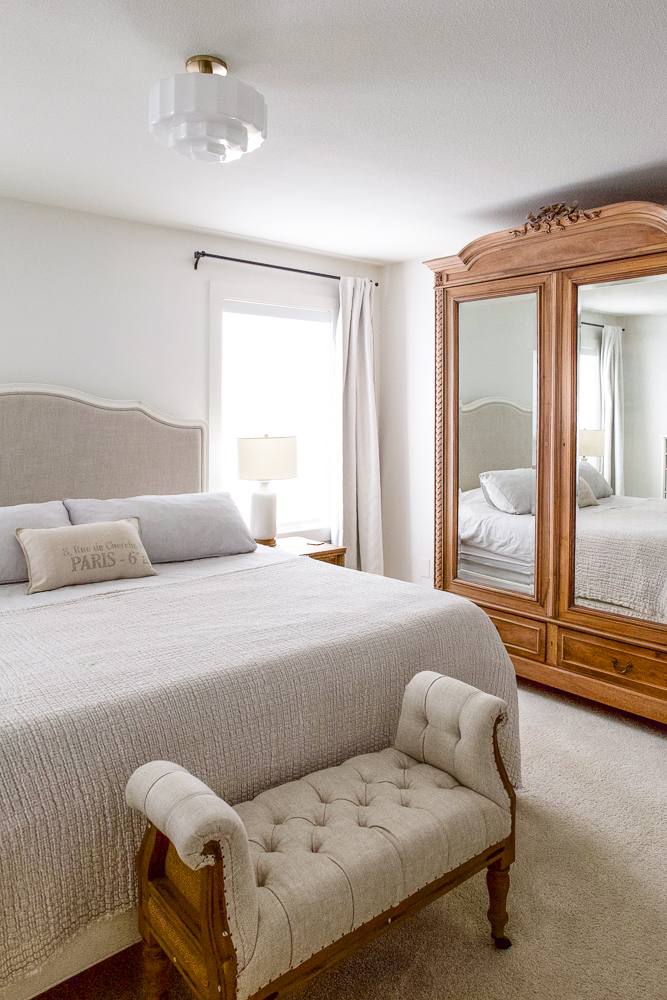 Mid century modern milk glass flush mount light fixture in neutral French vintage primary bedroom.