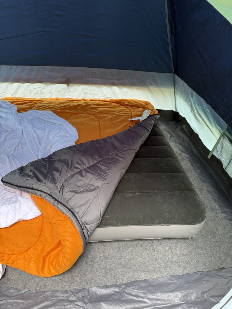 Making a cozy bed camping means adding thick sleeping bag to air mattress.
