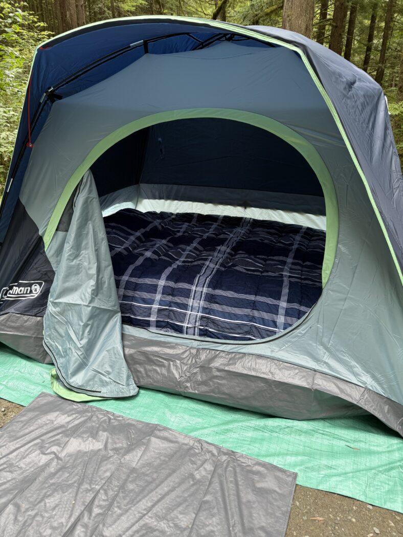 Tent and bed set up at a camp site.