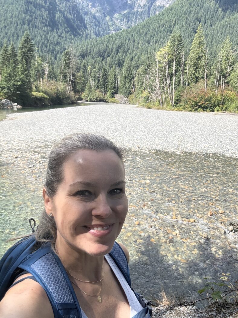 Woman hiking near a river.
