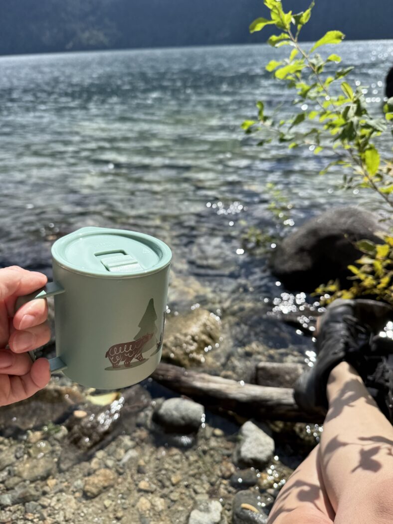 Sitting by lake enjoying a cup of tea or coffee.