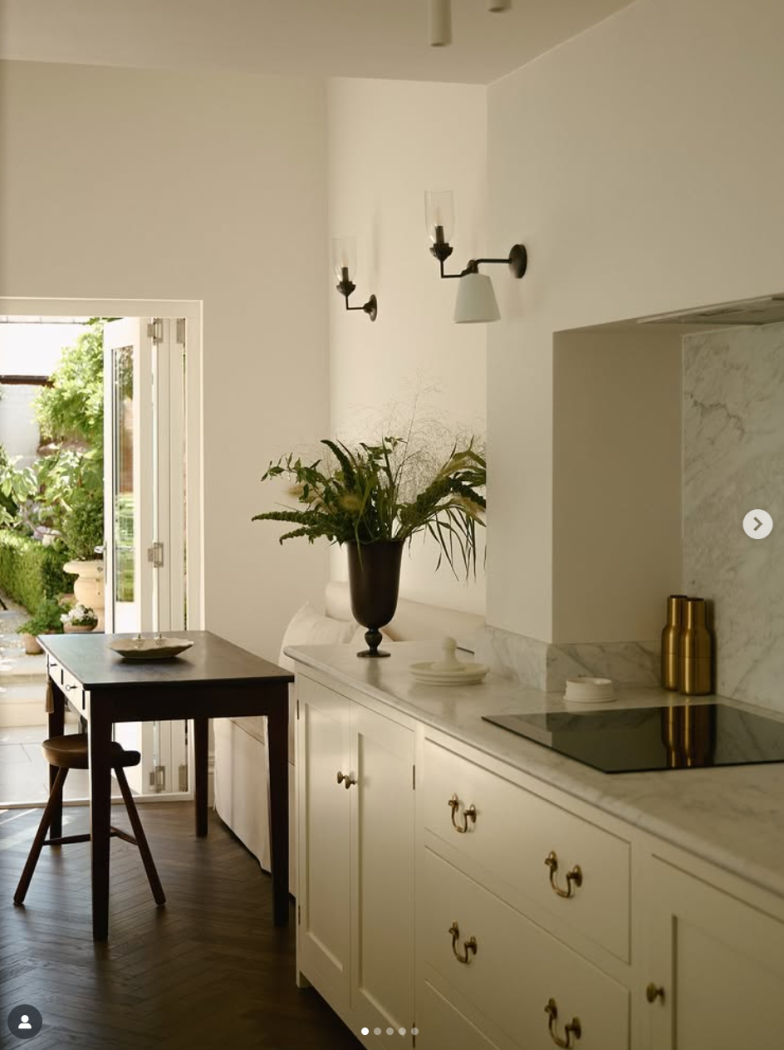 Creamy white minimalist kitchen with small nook eating area.