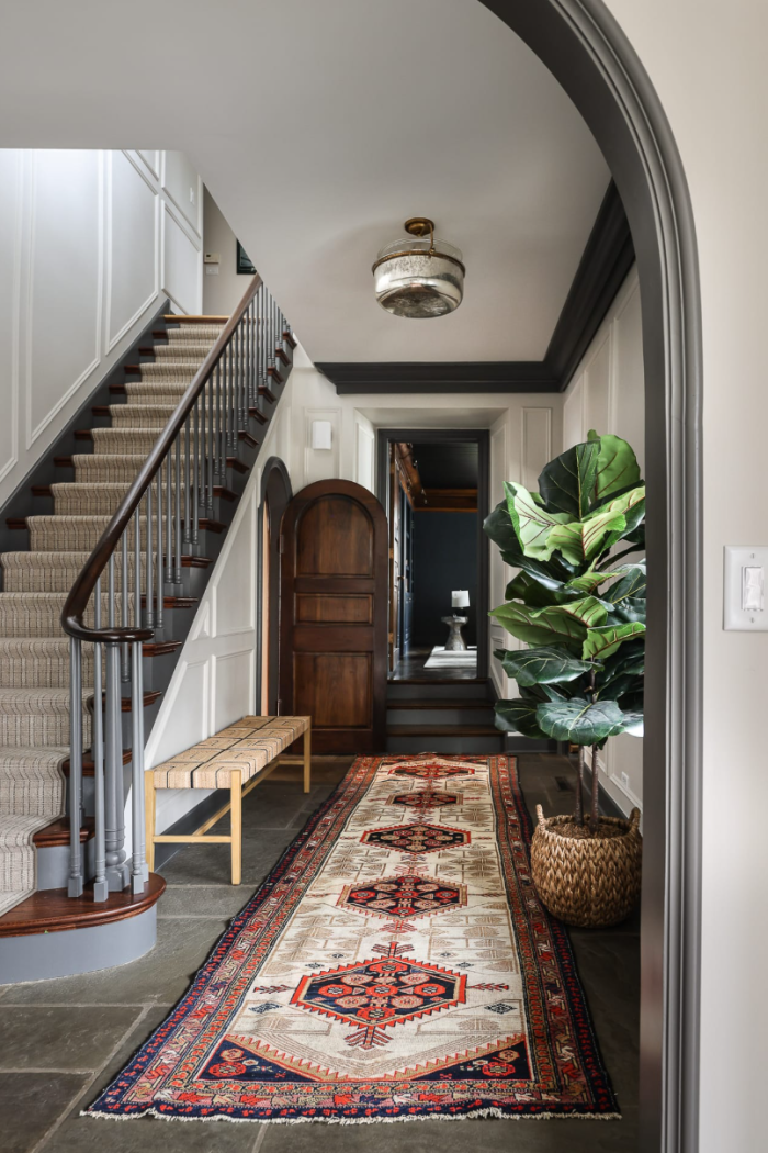 Grey trim painted with white painted walls entry way with arched doorway.