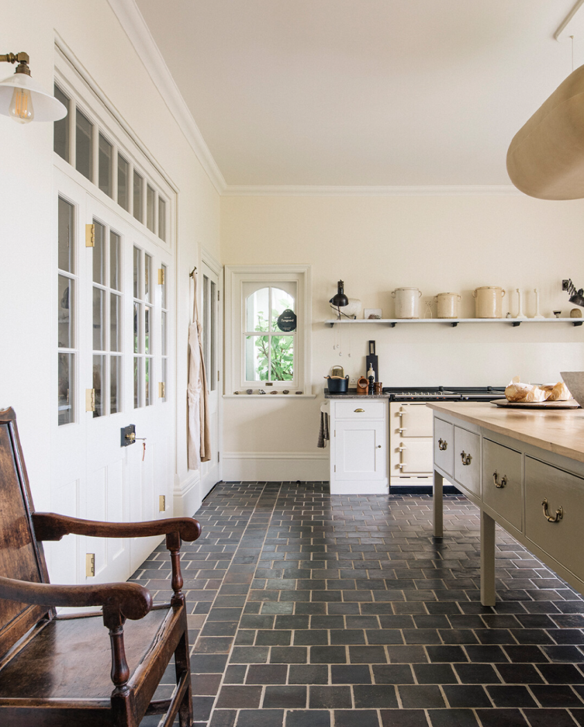 Large kitchen from Plain English kitchens with grey slate tile flooring and white and cream cabinetry.