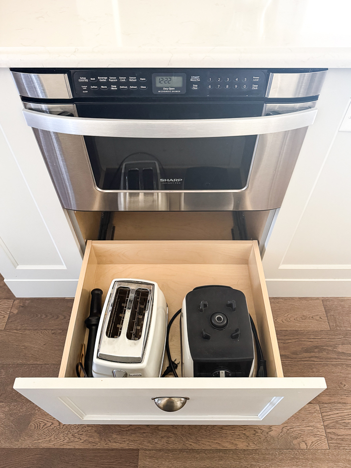 Sharp microwave drawer and drawer underneath with toaster and blender in it.