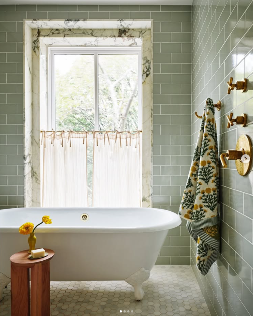 Green subway tile with white clawfoot tub.