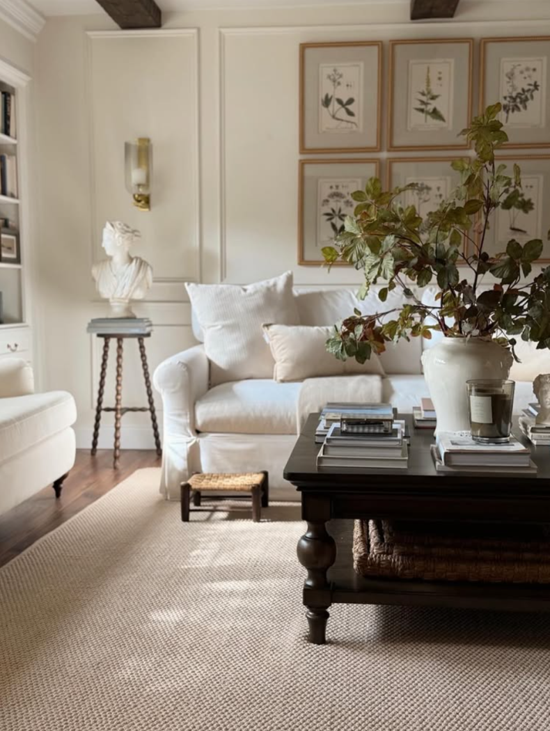 Living room with white slipcovered couch and gallery wall of botanicals behind it.